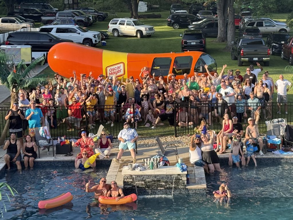 group photo at glizzy fest with wienermobile in back